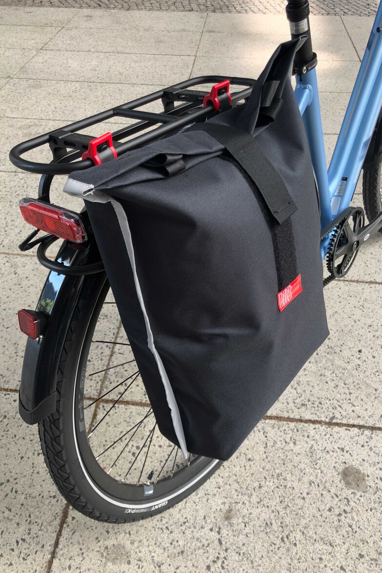 Der Hersteller Fahrer Berlin hat seiner überarbeiteten Einkaufstasche «Konsum» eine stabile, aber mittig faltbare Rückseite spendiert. Damit lässt sie sich per Klickfix-Verbindung am Gepäckträger befestigen. Bei Nichtgebrauch passt die Tasche in einen Rucksack. Foto: www.fahrer-berlin.de / pd-f
